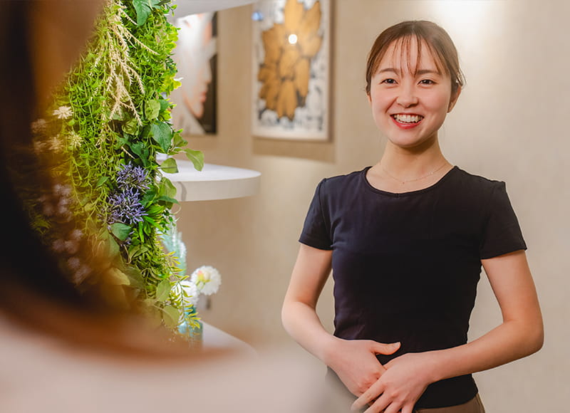 店内で女性客と会話するセラピスト